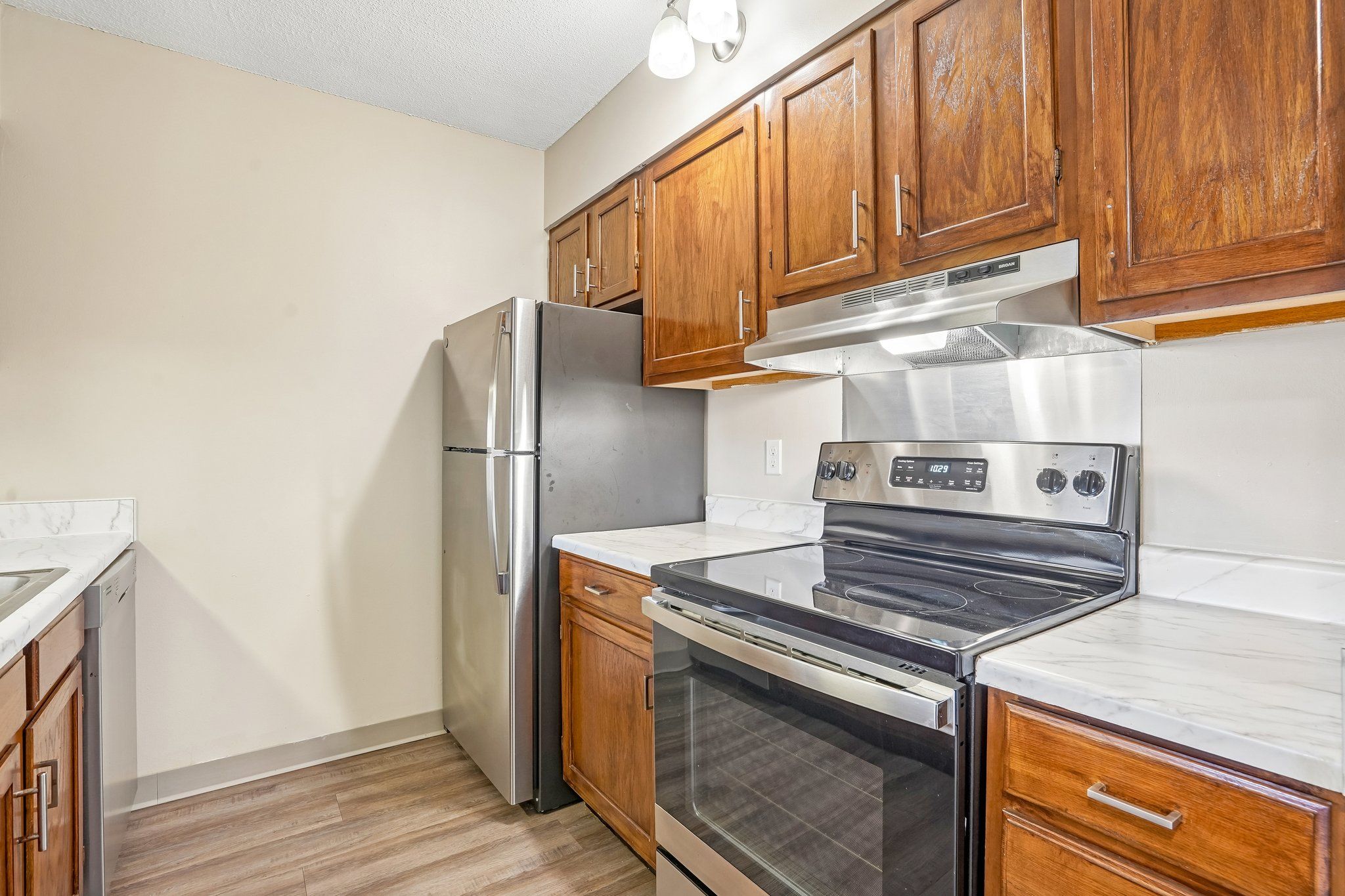 Irvine Park Towers apartment kitchen with wood cabinetry and breakfast bar opening to the living area